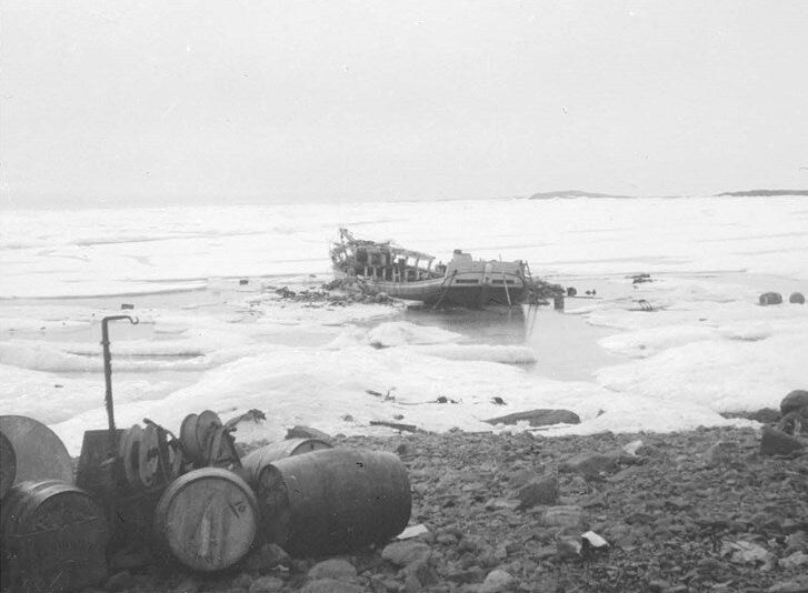 Photo of a wrecked ship on an icy beach.