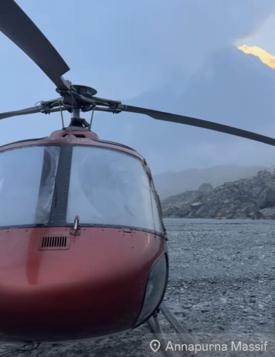 A helicopter on a scree landing spot in a foggy day. 