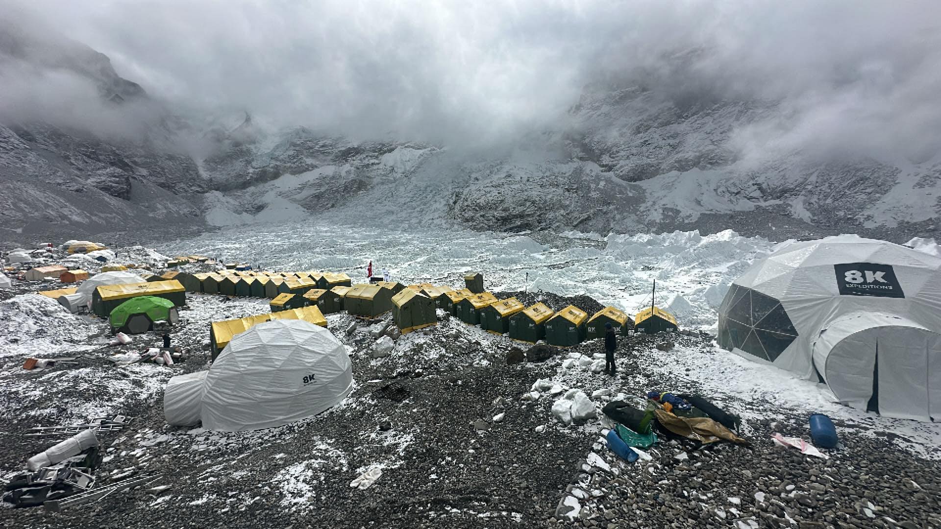 Tents in line on the Khumbu Glacier of Everest in a cloudy day.