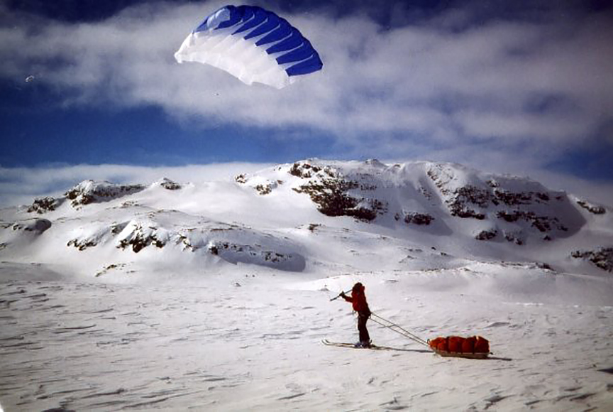 skier and sled pulled by kite
