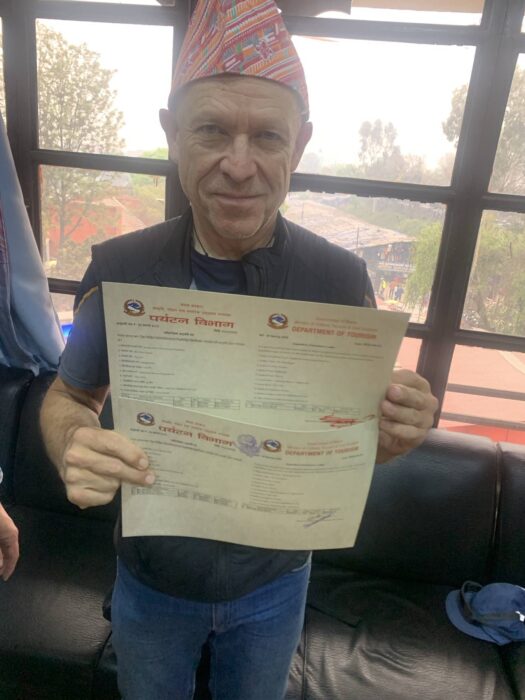 Peter Hamor holds two climbing permits at a DoT office.