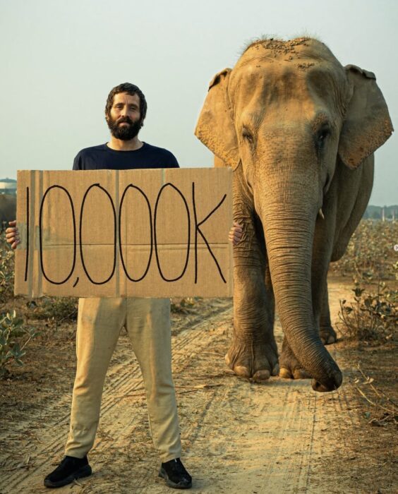 Hutchcraft poses with a 10,000 mark banner and an elefant.