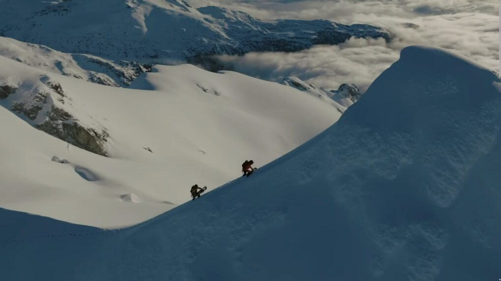 Two men hiking up a snowy mountain