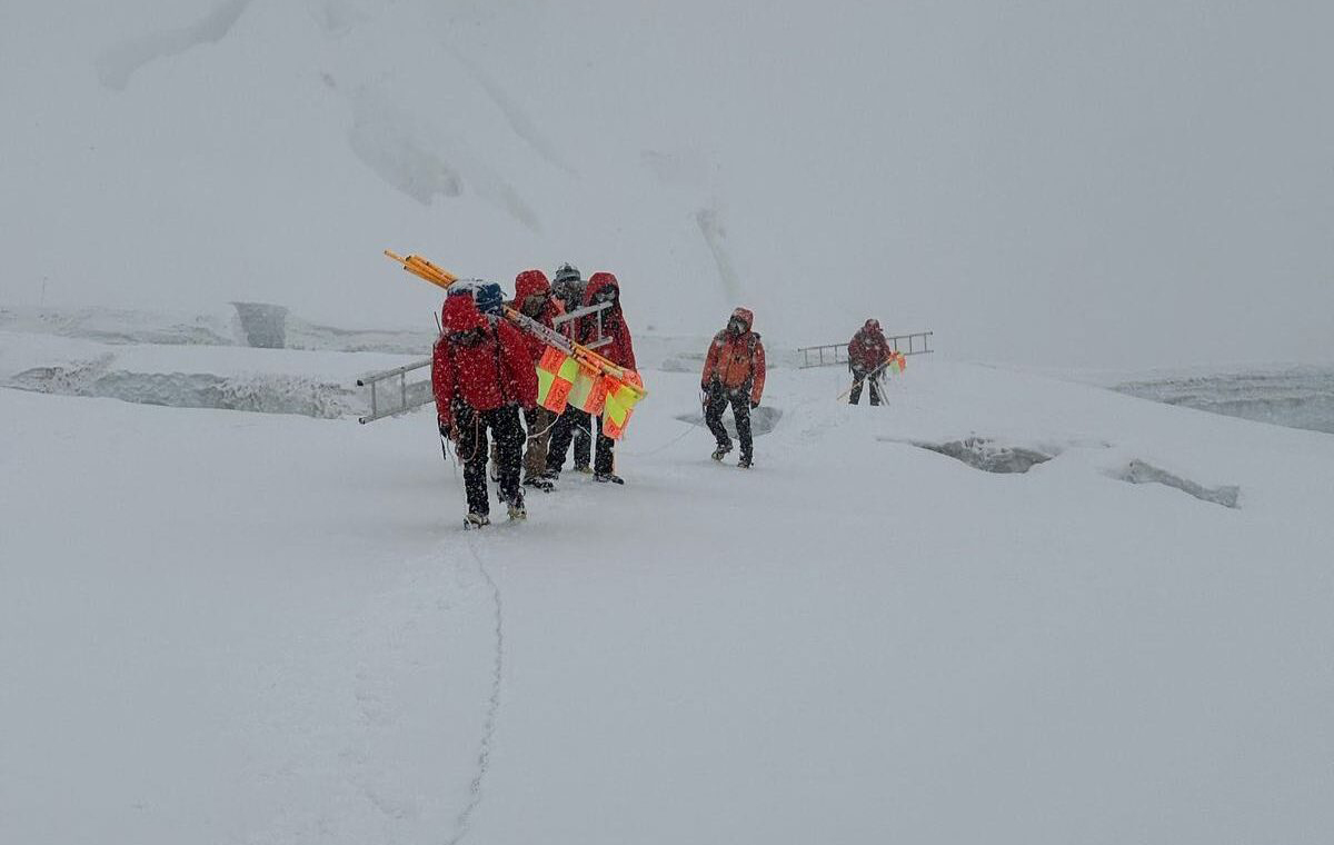 Sherpas with color flags heading up a glaicer area on Everest in a very foggy day.