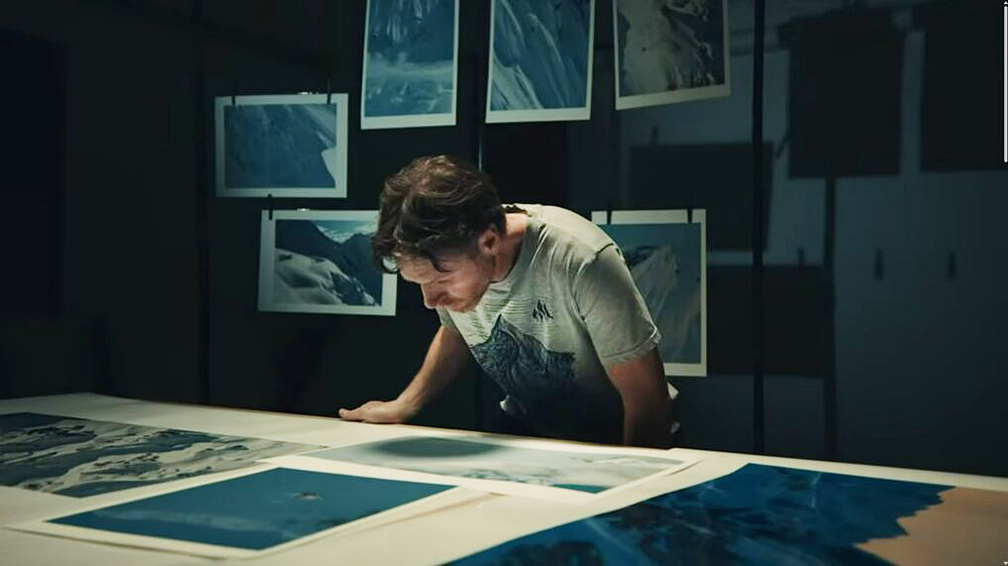 photographer looks at print on table