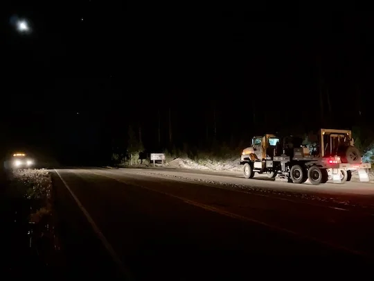 A large truck parked by the side of the road at night