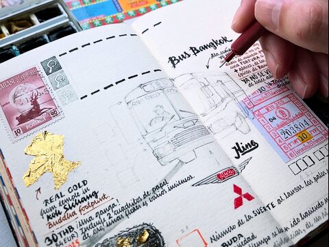 An open notebook page showing ephemera and a drawing of a bus.