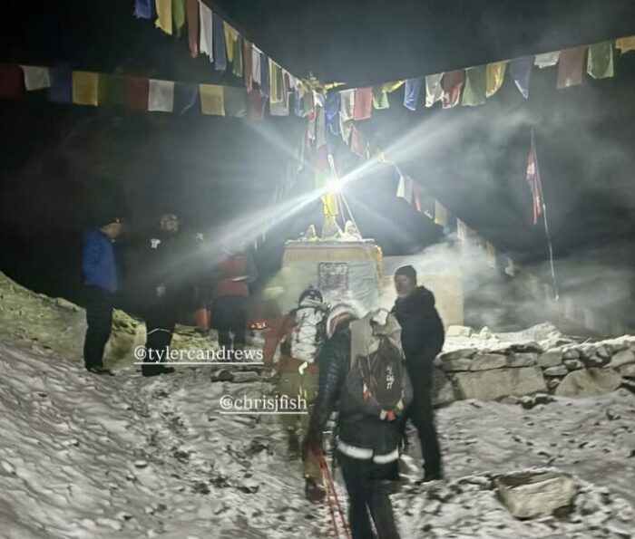 Tyler Andrews and Chris Fisher depart Everest Base camp in the night, passing by a chorten.