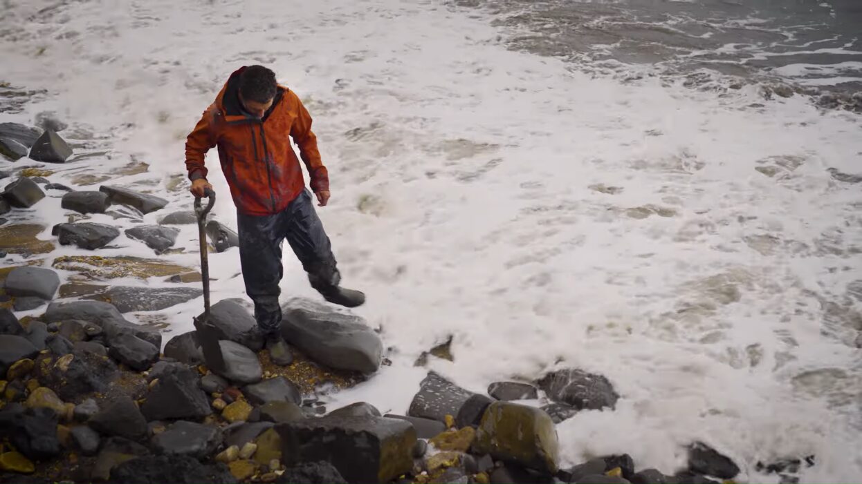 a man standing on a rocky beach