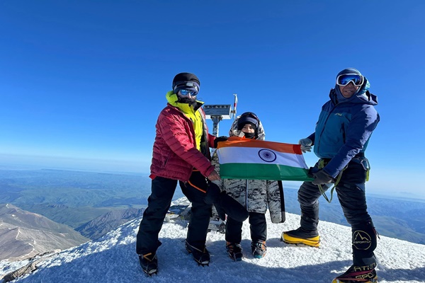 A little kid in a big jacket on the summit of Elbrus
