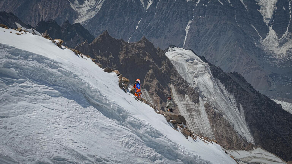 a climber on a snowy ridge.