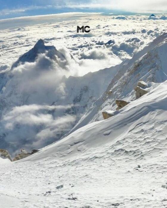 A mountain slope with some clouds below.