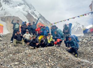 The Nepalese team by Imagine Nepal at K2 Base Camp, on morraine ground, in a cloudy day.