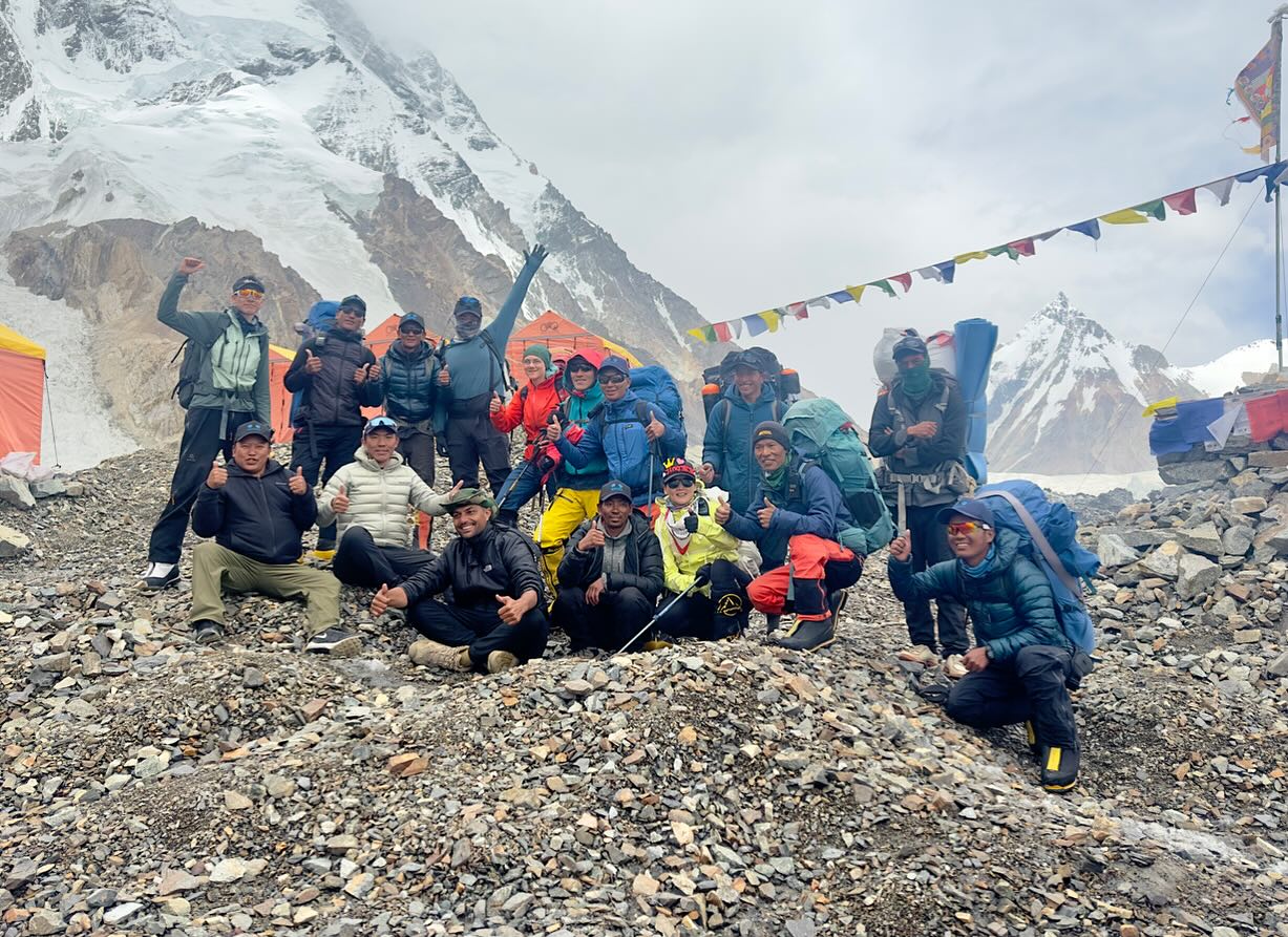 The Nepalese team by Imagine Nepal at K2 Base Camp, on morraine ground, in a cloudy day.