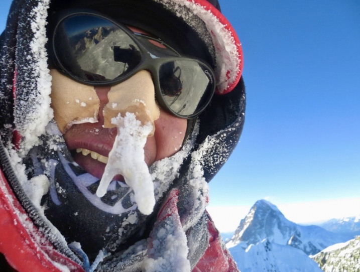 Adam Bielecki on the summit of Broad Peak, in winter, with K2 visible behind. 
