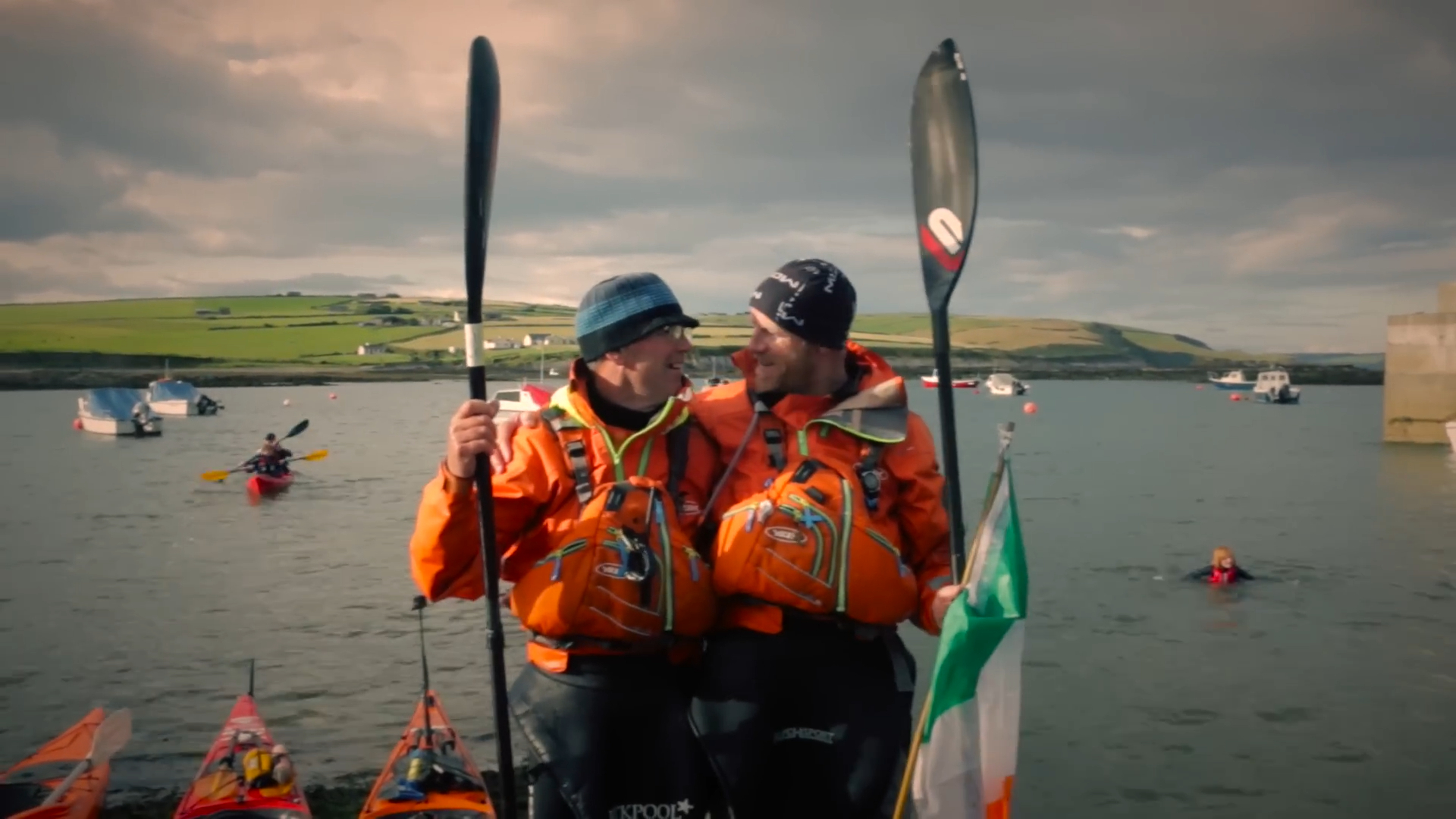 Two men with paddles, smiling