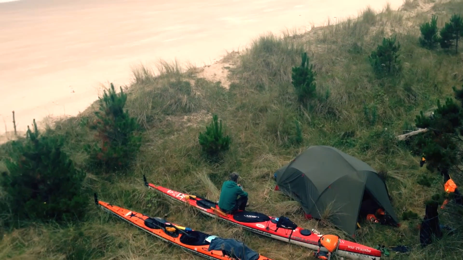 A campsite with tent and two kayaks