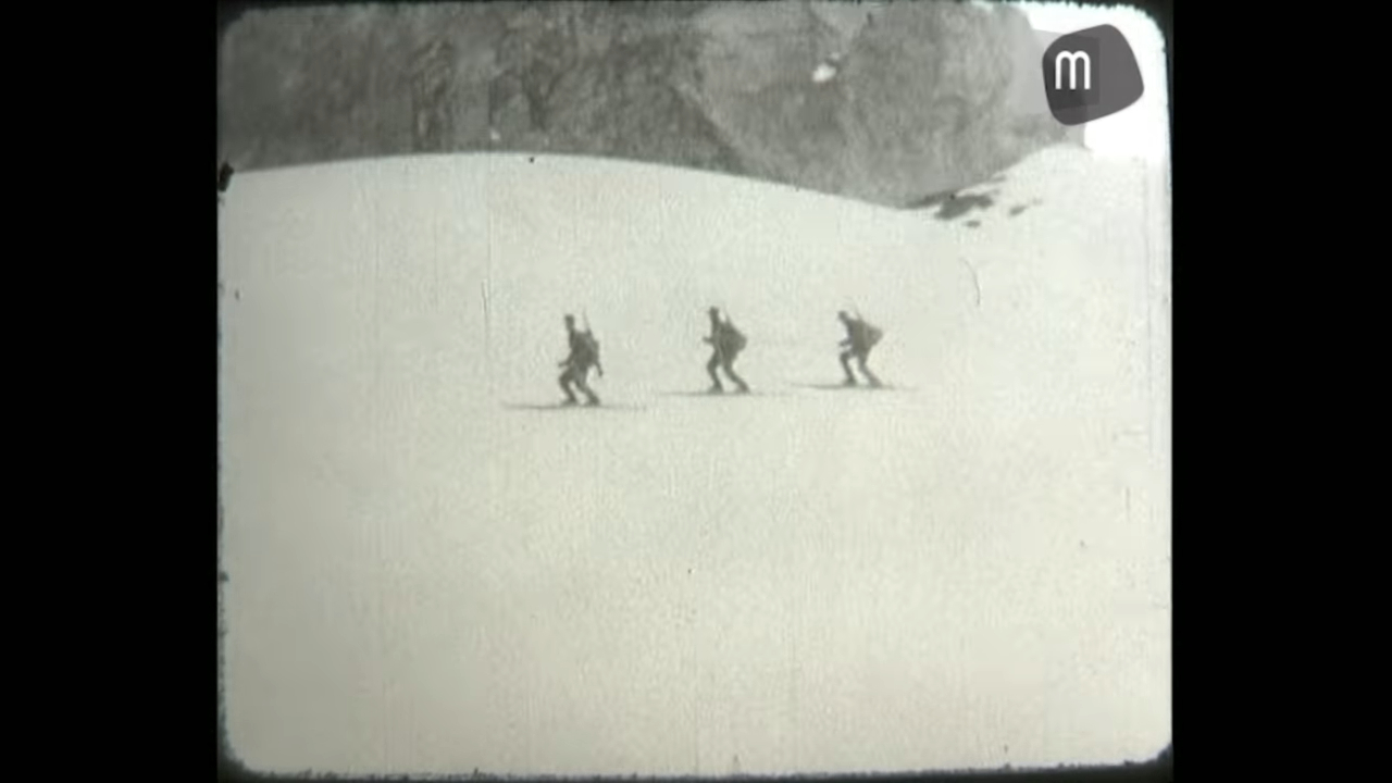 black and white video still of three skiers