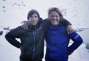 Groh and Holecek, shoulder to shoulder, with a background of a snowy mountain basin.