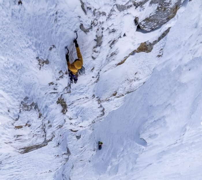 Two climbers on a vertical ice face.