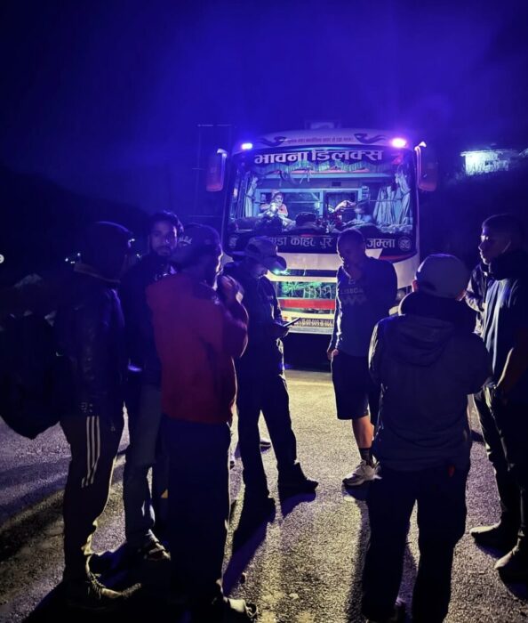 Climbers and passengers of a bus in Nepal stopped on the roed at night.
