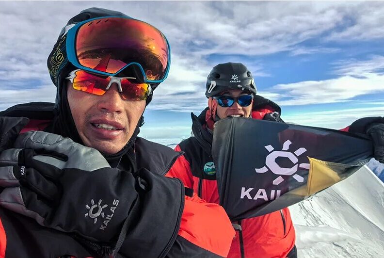 Chinese climbers take a selfie on a mountain top.