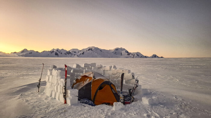 A tent protected by a snow brick wall.