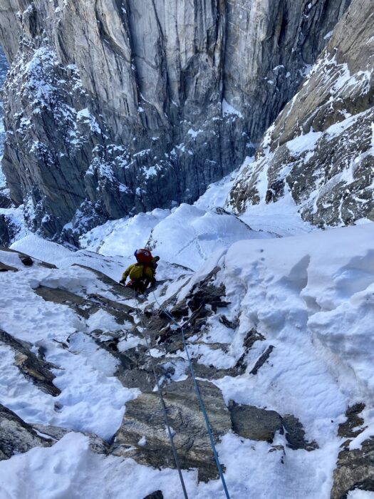 A climber on mixed terrain, very vertical and with the void at his feet.