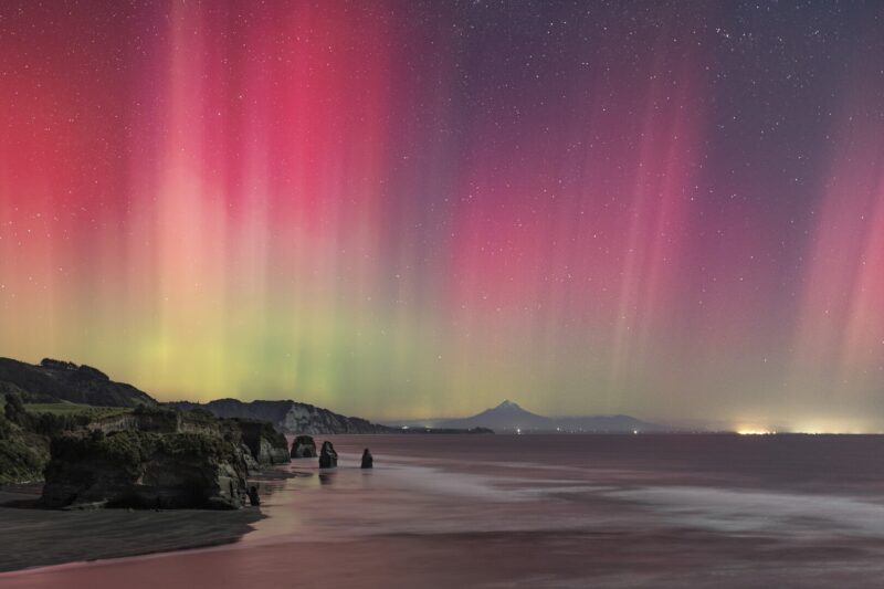 A rare aurora event lit the west coast of New Zealand’s North Island in vivid curtains of pink and green