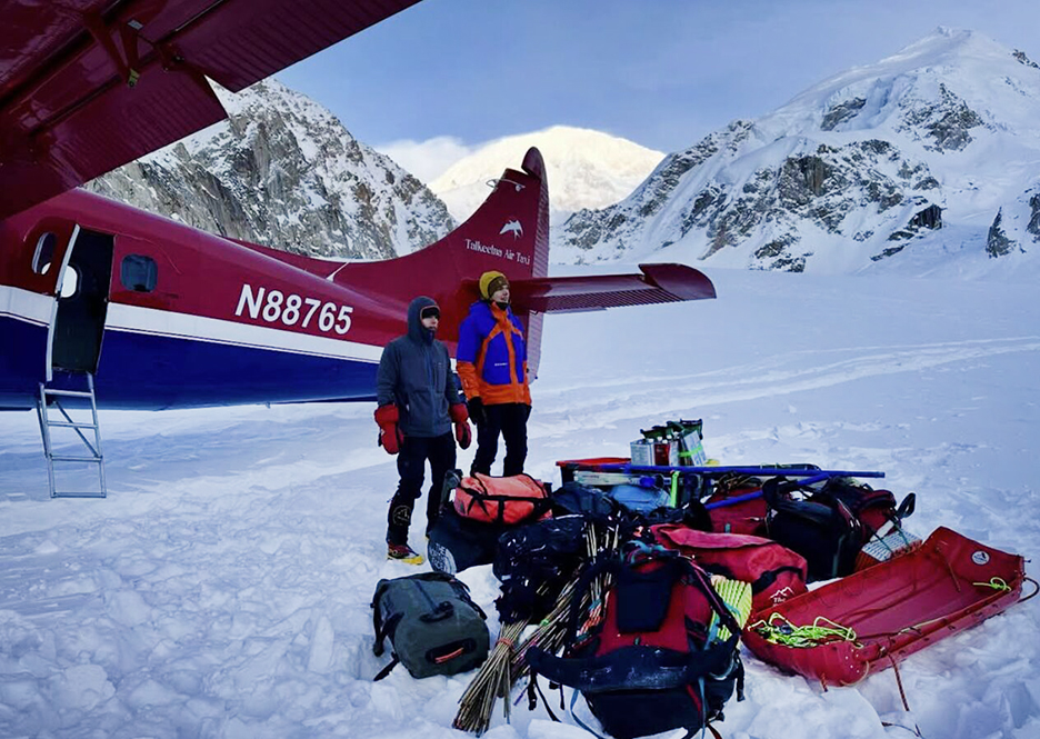 two climbers beside bush plane on glacier