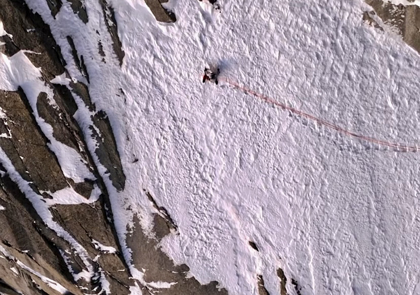 small climber on snowy wall