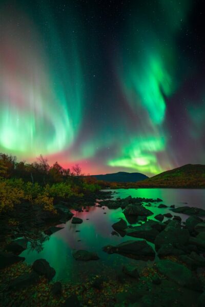 Green and pink aurora over Lake Torneträsk in Sweden