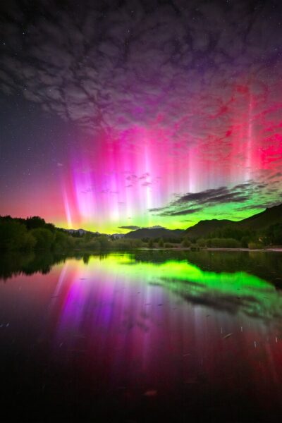 A bright aurora reflected in a secluded pond