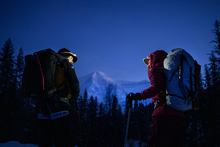 The climbers at dawn, with headlamps on, approaching a mountain.