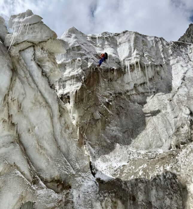 A climber rapelling down seracs.