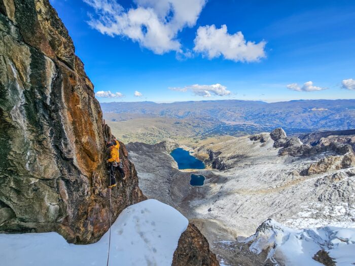 A climber on a mostly rocky face in Peruvian Andes.