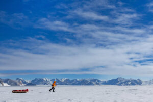 single person sledding in Antarctica against mountains