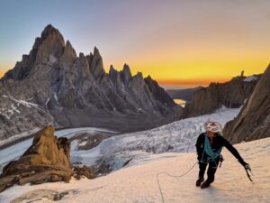 A lclimber on an ice ramp, Fitz Roy in background at dawn.