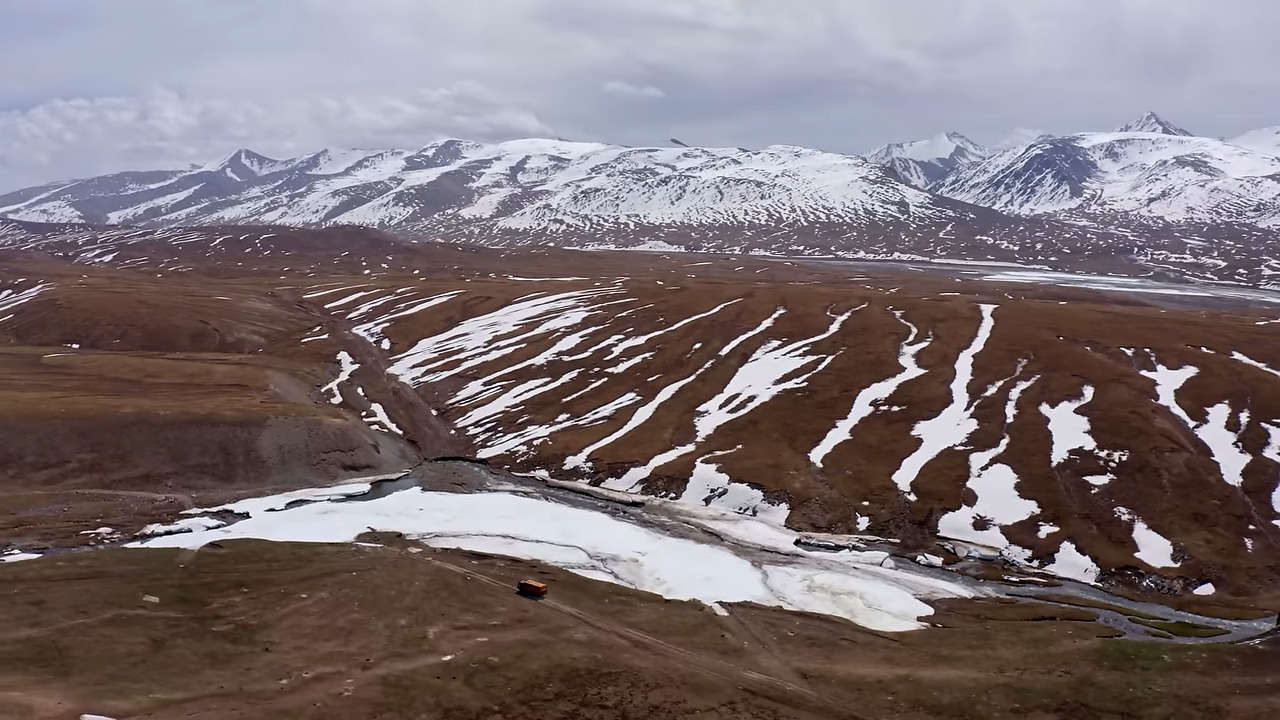 A van driving towards snowy mountains