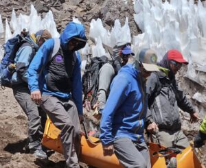 rescuers carry a litter with an injured climber