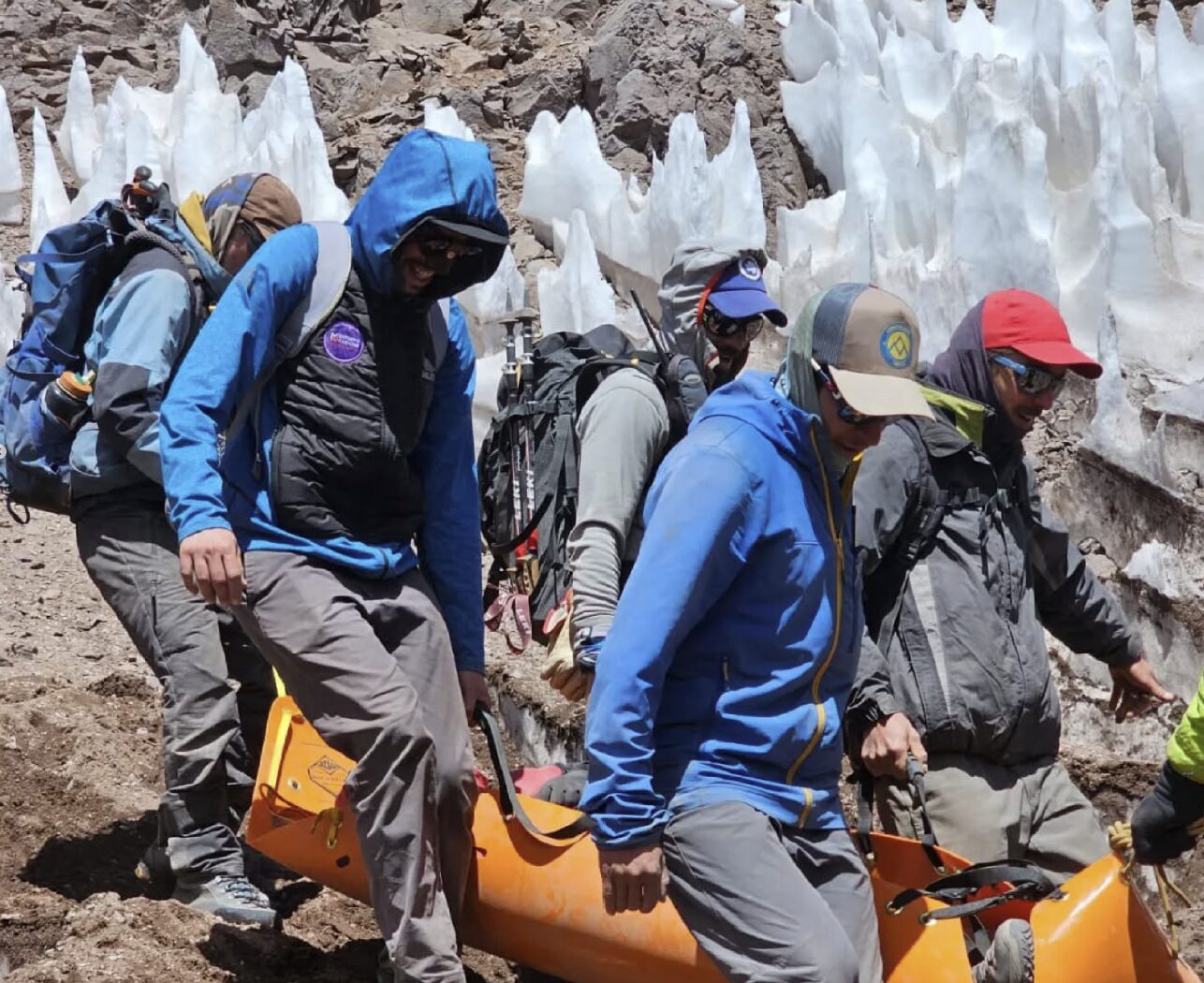 rescuers carry a litter with an injured climber