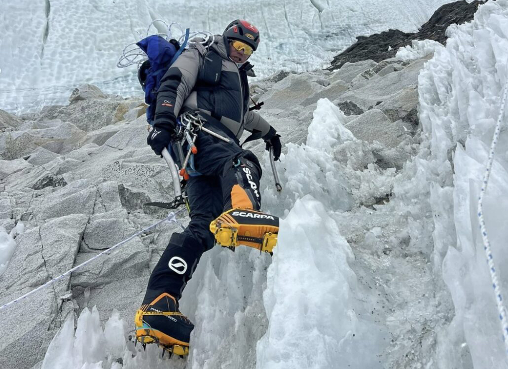 Sanu Sherpa in mountaineering outfit on an icefall with a big serac behind him.