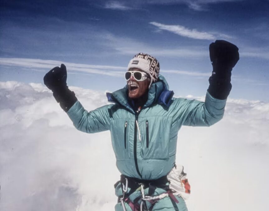 a man in a turquoise jacket cheering