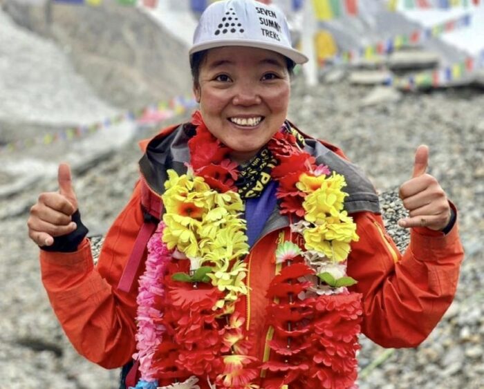 Close shot of He Jing with a paper flower garland around her neck.