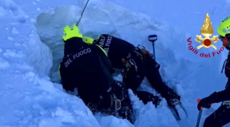 Rescuers at an avalanche site in the Italian Alps, recovering victims that are buried below meters of snow.