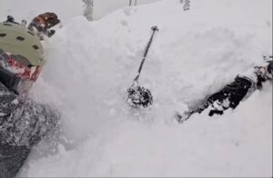 skier tries to unbury another skier