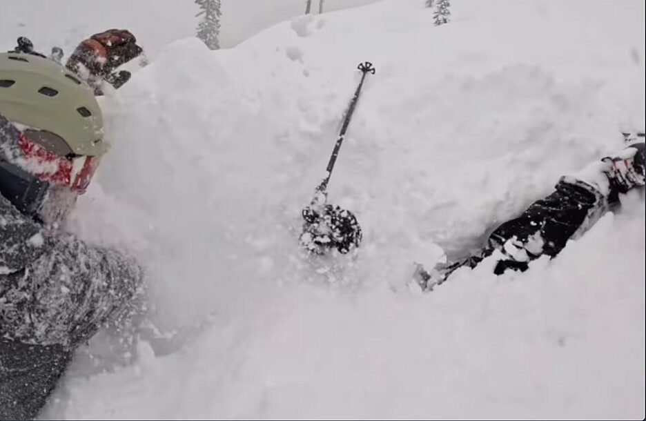 skier tries to unbury another skier