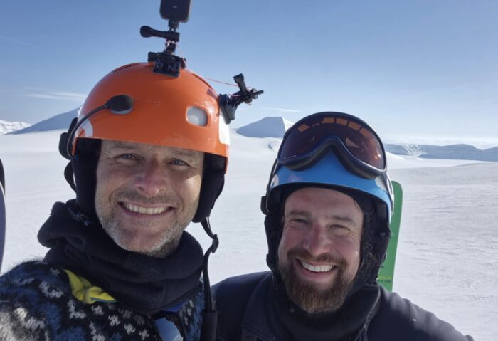 Norwegian and Danish snow kite guides Thomas Sorensen and Morten Rejkjaer stand next to each other in a snowy landscape
