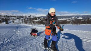 young girl skiing and pulling sled