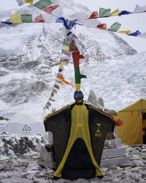 Tim Howell wearing a winduit in front of a chorten in Everest BC.